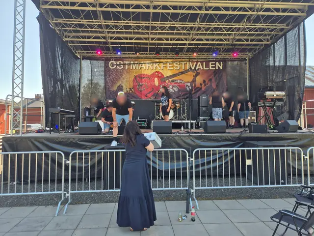 Band och crew förbereder scenen inför spelning framför publikstaketet.