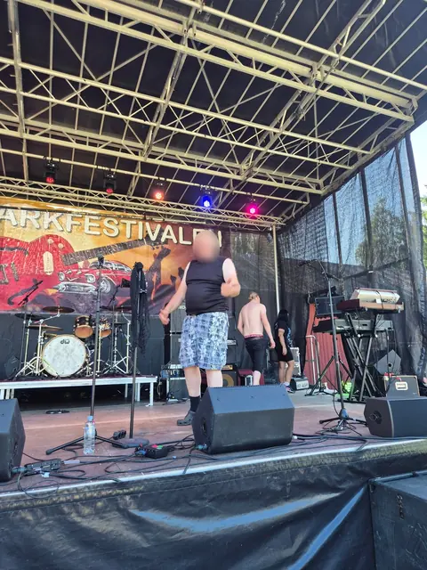 Musiker på stora scenen under soundcheck en solig eftermiddag.